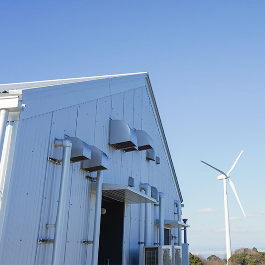 空調設備が設置された工場の外観と風力発電機